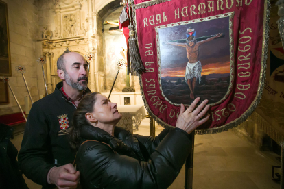 Una usuaria de la ONCE toca un estandarte de la Real Hermandad de la Sangre del Cristo de Burgos.
