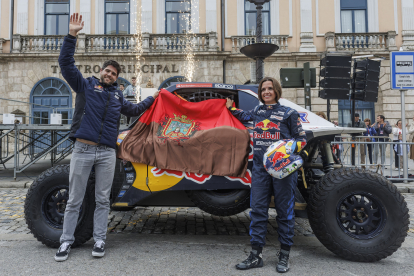 La pareja ganadora del Dakar posa con el coche y la bandera de Burgos