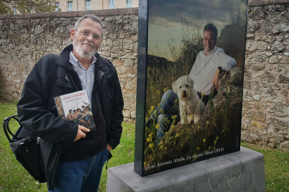 José Antonio Abella posa en los jardines del Palacio de la Isla junto a su retrato de la exposición Galaxia Crítica, obra del fotógrafo Asís G. Ayerbe.