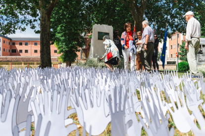 Una ofrenda floral entre las manos blancas que recuerdan el espíritu de Ermua