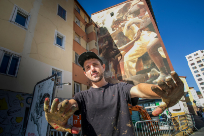 Guido Palmadessa posa justo delante de la nueva obra de arte urbano que se puede visitar en Burgos, en la plaza Hortelanos.