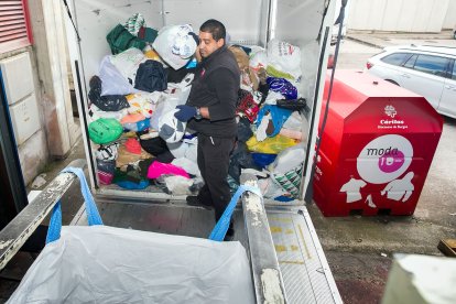 Un empleado descarga las bolsas de ropa recogidas de los contenedores de Cáritas.