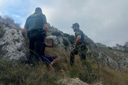 El menor bebe agua después de ser localizado por dos de los agentes en una ladera del desfiladero de Pancorbo.