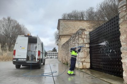 Limpieza de pintadas en una puerta de acceso a la Universidad de Burgos.