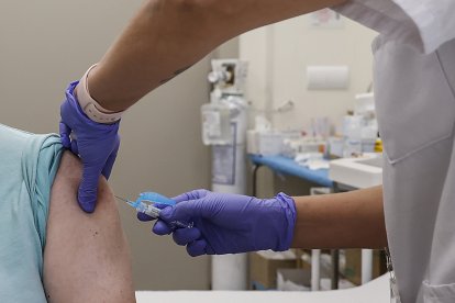 Archivo - Una mujer se vacuna durante el inicio de la campaña de vacunación frente a la gripe y la Covid-19.