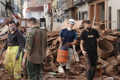 Efectivos de Castilla y León realizan labores de ayuda en las calles de Aldaya (Valencia). Vecinos de Aldaya limpian las calles del centro del pueblo