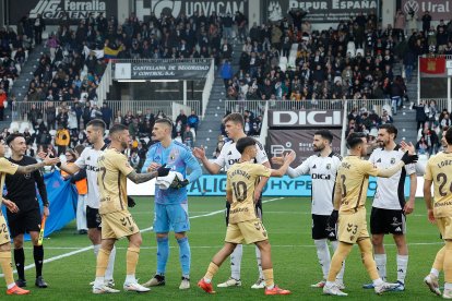 Los jugadores de ambos equipos se saludan antes del comienzo del partido.