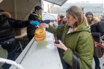 Una mujer compra los tradiciones panecillos de San Lesmes.