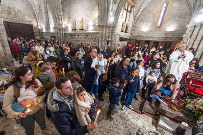 Las velas y el corro ante la pila bautismal es una de las imágenes más típicas de esta tradición del barrio de Gamonal.