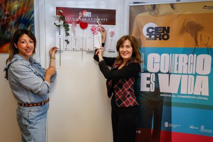 Gil y Marticorena sostienen el cartel con flores que se colgará en 75 comercios.