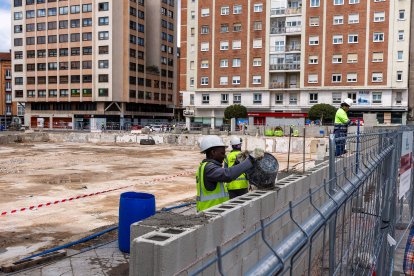 Los operarios trabajan en la construcción del muro que rodeará el solar donde se encontraba el antiguo Mercado Norte.