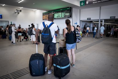 Varias personas esperan con maletas y observan los carteles de salidas, en la estación de Chamartín Clara Campoamor, a 14 de agosto de 2025, en Madrid (España).
