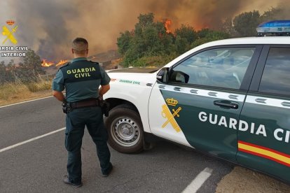 Un coche de la Guardia Civil frente a un incendio.