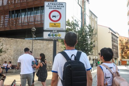 Varias personas junto a una de las señales de entrada a la ZBE de Burgos.