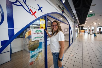 Delia, dependienta de la administración del El Mirador posan con el cartel del premio.