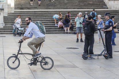 Agentes de la Policía Local paran a unos jóvenes en patinete eléctrico en la Plaza del Rey San Fernando.
