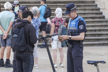 Agentes de la Policía Local paran a unos jóvenes en patinete eléctrico en la Plaza del Rey San Fernando.
