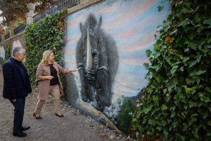 Roberto Saiz y Cristina Ayala contemplan uno de los animales prehistóricos recreados en el mural a orillas del Arlanzón.