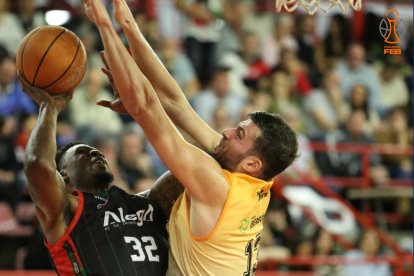 Ramón Vilà trata de bloquear al jugador rival Reginald "Reggie" Johnson Jr.