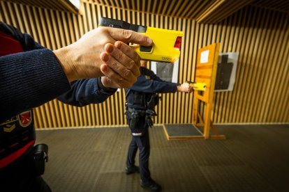 Dos agentes realizan una demostración de uso de la pistola táser.