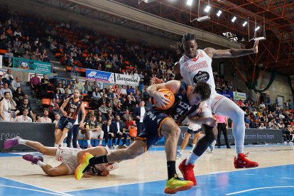Gabriel Gil pelea para llegar a la canasta ante la oposición de los jugadores del Ourense, este domingo en El Plantío.
