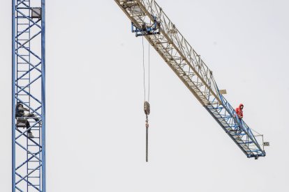 Imagen de los dos trabajadores subidos a la grúa.