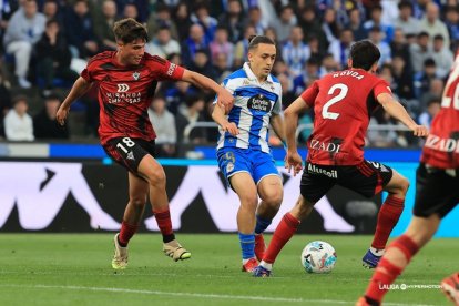 Los rojillos Bauza y Novoa intentan robar el balón al deportivista Luismi Cruz