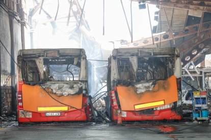 Imagen de dos autobuses quemados.