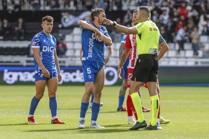El colegiado Salvador Lax da explicaciones al capitán del Burgos CF, Atienza, durante el encuentro ante la UD Almería.
