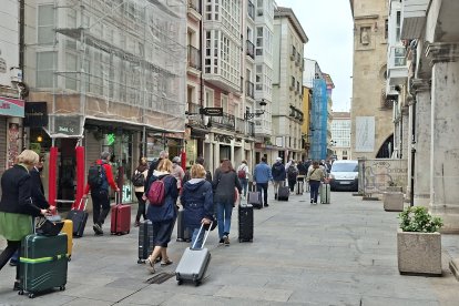 Un numeroso grupo de turistas caminando la semana pasada con sus maletas por la calle de La Paloma.