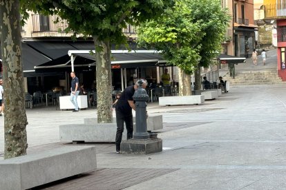 Un hombre bebe de la fuente en la plaza Mayor