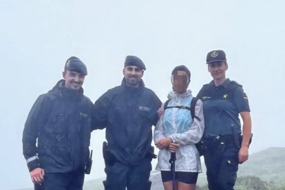 Los agentes con la senderista rescatada.