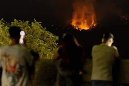 Varias personas observan el incendio, a 25 de julio de 2026, en San Martín de Valdeiglesias, Madrid (España). Durante la noche ha beneficiado el cambio de condiciones meteorológicas, con menos viento, mayor humedad y menos temperatura, aunque el fuego sig.