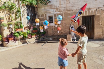 Dos niños miran una de las decoraciones de Olmillos de Sasamón.