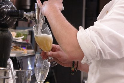 Archivo - Camarero en tirador de cerveza.