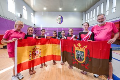 Las gimnastas y los técnicos mundialistas posando con la bandera de España y de Burgos