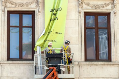 Imagen de dos trabajadores en la fachada de un edificio.