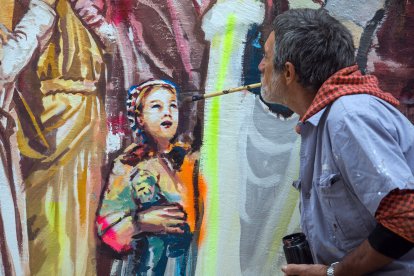 Un pintor bromea pintando una cara con el pincel en la boca. T.A.