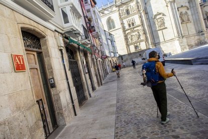 Un peregrino junto a un edificio de alojamientos turísticos en el centro histórico, que concentra la mayoría de estos pisos. SANTI OTERO