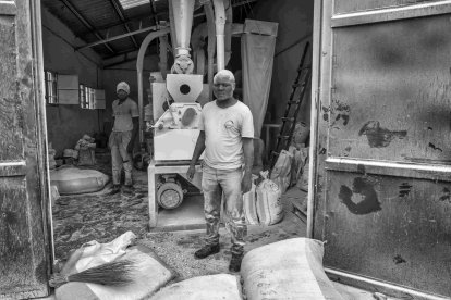 Eduardo Margareto / ICAL. Justin Isevandu, es el responsable técnico de la fábrica. Ha puesto en marcha la máquina harinera, una labor complicada, y controla que todos los procesos de fabricación estén correctos. Al fondo Romiliade Kambale uno de los trabajadores de la harinera, que tiene una voz muy especial, es uno de las primeras voces del coro de Rubare