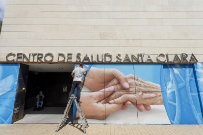 Christian Saldaña trabaja en el mural que está rematando en el centro de Salud de Santa Clara. FOTOS: © ECB / SANTI OTERO