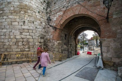 Unos peatones cruzan por el Arco de San Martín en dirección a la calle Fernán González. TOMÁS ALONSO