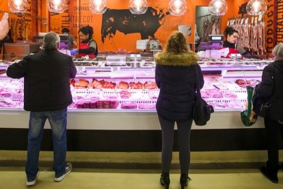 Tres clientes esperan su turno en una carnicería del Mercado de Gamonal. TOMAS ALONSO