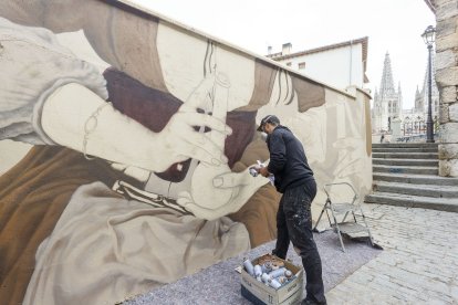 Christian Sasa trabaja en el mural del Callejón de las Brujas. SANTI OTERO