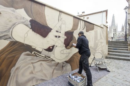 Christian Sasa trabaja en el mural del Callejón de las Brujas. SANTI OTERO