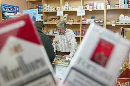 Una persona compra tabaco en un estanco.-