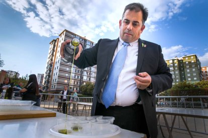 El alcalde de Cabra del Santo Cristo, Francisco Javier Justicia, escancia aceite de su pueblo para la degustación en la barriada Juan XXIII. TOMÁS ALONSO