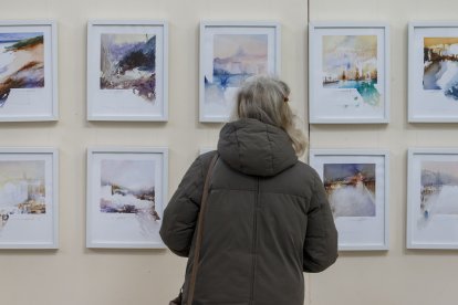 Una mujer aprecia una serie en la feria. SANTI OTERO