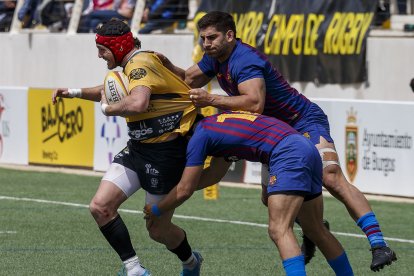 Facu López intenta progresar ante el esfuerzo defensivo de los jugadores del Barcelona. SANTI OTERO