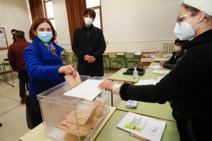 Marga Arroyo, con Juan Gascón al fondo, vota en su colegio electoral. TOMÁS ALONSO